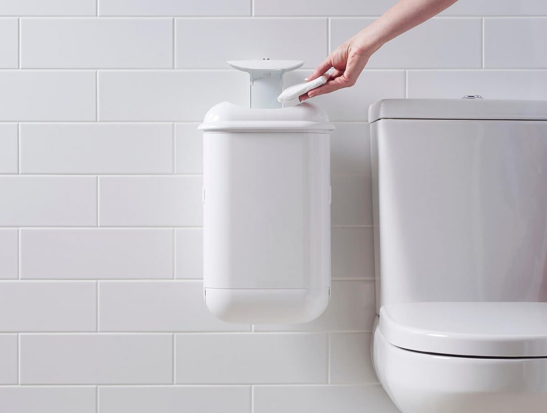 A person disposing sanitary waste into Pod Petite sanitary pad disposal automatic unit