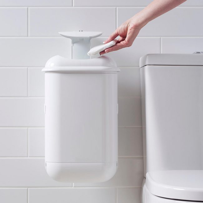 A person disposing sanitary waste into Pod Petite sanitary pad disposal automatic unit