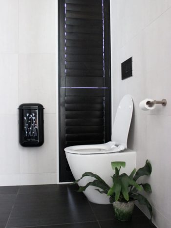 The black Pod Petite sanitary disposal unit with a Pod Wrap Poppies design decal