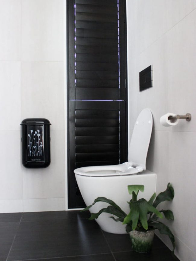 The black Pod Petite sanitary disposal unit with a Pod Wrap Poppies design decal