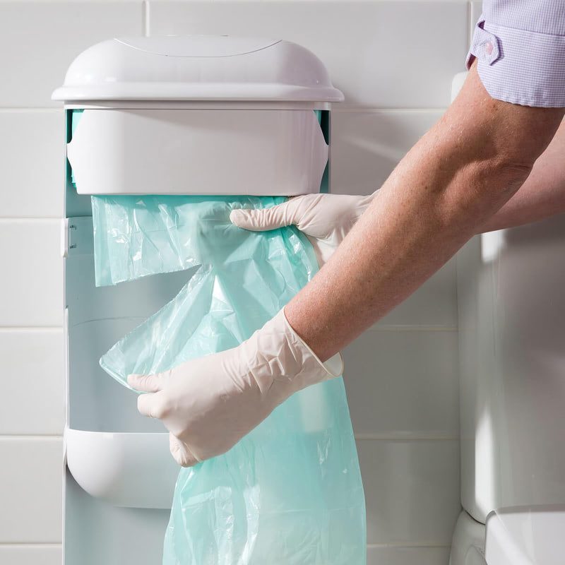 A cleaner servicing Pod Petite unit by tearing off used liner